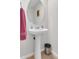 Simple powder room with a pedestal sink, round mirror, and neutral paint color at 5807 Mitchell Chase Trl, Mableton, GA 30126