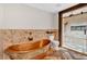 Beautiful bathroom featuring copper soaking tub, luxurious stone shower, and a unique barnwood frame at 161 Old Vandiver Dr, Canton, GA 30114