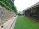 Landscaped backyard featuring lush lawn and stone retaining wall at 330 La Perla Dr, Sugar Hill, GA 30518