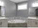 Bright primary bathroom featuring dual sinks, a soaking tub, and neutral tiling at 330 La Perla Dr, Sugar Hill, GA 30518