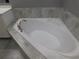 Close up of a soaking tub in a bright primary bathroom with neutral tiling at 330 La Perla Dr, Sugar Hill, GA 30518