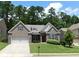 Charming brick home with manicured lawn and two-car garage in a lush, green setting at 330 La Perla Dr, Sugar Hill, GA 30518