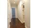 Bright hallway with hardwood floors leads to an open doorway with a glimpse of the room beyond at 330 La Perla Dr, Sugar Hill, GA 30518
