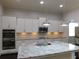 Bright kitchen features stainless steel appliances, granite countertops, and white cabinetry at 330 La Perla Dr, Sugar Hill, GA 30518