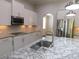 Kitchen features granite countertops, stainless steel appliances, and island with sink at 330 La Perla Dr, Sugar Hill, GA 30518
