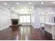 Open floorplan living room featuring a stone fireplace, hardwood floors, and a granite counter top island at 330 La Perla Dr, Sugar Hill, GA 30518
