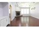 Living room featuring a stone fireplace, a row of well lit windows and beautiful hardwood floors at 330 La Perla Dr, Sugar Hill, GA 30518