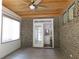 Covered brick patio with tile floors, ceiling fan and view to the kitchen with stainless steel appliances at 330 La Perla Dr, Sugar Hill, GA 30518