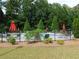 Community pool surrounded by lounge chairs, red umbrellas, and lush landscaping for relaxing outdoors at 330 La Perla Dr, Sugar Hill, GA 30518