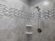 Beautifully tiled shower with mosaic accents, handheld sprayer, and soap dishes at 330 La Perla Dr, Sugar Hill, GA 30518