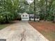 Charming yellow two-story home with a two-car garage and inviting front porch surrounded by lush trees at 48 Glenhaven Ct, Douglasville, GA 30134
