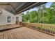 Spacious wooden back deck with awning, wooden railing, and stairs to backyard with mature trees at 1320 Pinyon Pl, Lawrenceville, GA 30043