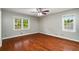 Spacious bedroom with hardwood floors, neutral paint, and great natural light from two windows at 1320 Pinyon Pl, Lawrenceville, GA 30043