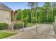 Gated driveway leading to expansive backyard with mature trees and shed surrounded by privacy fence at 1320 Pinyon Pl, Lawrenceville, GA 30043