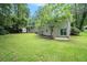 The backyard features a well-manicured lawn and white brick exterior with a sliding glass door and mature trees at 1534 Sw Austin Sw Rd, Atlanta, GA 30331