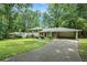 Split-level home with well-maintained lawn, brick facade, and covered parking, surrounded by mature trees at 1534 Sw Austin Sw Rd, Atlanta, GA 30331