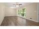 Spacious living room with wood-look flooring, ceiling fan, and large window showcasing the front yard at 1534 Sw Austin Sw Rd, Atlanta, GA 30331