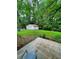 View from the patio of the backyard and detached garage, surrounded by trees at 287 Willow Cove Ct, Lawrenceville, GA 30044
