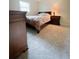 Comfortable bedroom featuring carpeted floor, wooden dresser and a window for natural light at 287 Willow Cove Ct, Lawrenceville, GA 30044