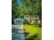 Charming two-story home featuring lush green lawn, classic black shutters, and lovely trees surrounding the property at 287 Willow Cove Ct, Lawrenceville, GA 30044