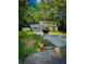 Charming two-story home featuring lush green lawn, mailbox with colorful flowers, and lovely trees surrounding the property at 287 Willow Cove Ct, Lawrenceville, GA 30044