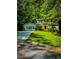 Charming two-story home featuring lush green lawn, classic black shutters, and lovely trees surrounding the property at 287 Willow Cove Ct, Lawrenceville, GA 30044