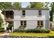 Two-story home featuring a charming yellow door, complemented by manicured landscaping and black and white awning at 3158 Granby Ave, Scottdale, GA 30079