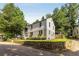 Rear view of a home with a stone retaining wall, landscaping, and easy access to street at 3158 Granby Ave, Scottdale, GA 30079