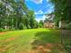 Spacious backyard with mature trees surrounding the lawn, offering a peaceful and private outdoor retreat at 4086 Rex Road, Rex, GA 30273