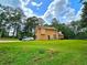 Spacious backyard featuring a well-maintained lawn, ample parking, and bordered by lush trees at 4086 Rex Road, Rex, GA 30273
