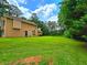 Expansive backyard with green lawn and storage shed, perfect for outdoor activities and relaxation amidst mature trees at 4086 Rex Road, Rex, GA 30273