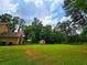 Spacious backyard with well-maintained lawn, storage shed, and lush greenery, ideal for outdoor enjoyment at 4086 Rex Road, Rex, GA 30273
