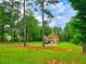 Charming home nestled among tall trees, featuring a long driveway, green lawn, and ample parking space at 4086 Rex Road, Rex, GA 30273