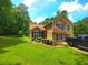 Charming two-story home featuring tan siding, a manicured lawn, and an American flag at 4086 Rex Road, Rex, GA 30273