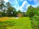 Inviting home with well-kept lawn and parking, framed by trees under a sky with white clouds at 4086 Rex Road, Rex, GA 30273