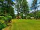 A tan two-story home featuring an expansive front yard, lush greenery, and ample space at 4086 Rex Road, Rex, GA 30273