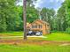 Inviting two-story home with a well-maintained lawn and parking, surrounded by lush greenery and mature trees at 4086 Rex Road, Rex, GA 30273