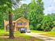 A tan two-story home with a brick chimney, black shutters, and ample yard space at 4086 Rex Road, Rex, GA 30273