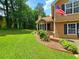 Beautifully landscaped front yard with lush green lawn and brick-lined flowerbeds at 4086 Rex Road, Rex, GA 30273