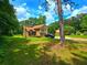 Front yard view showcasing a well-maintained lawn, mature trees, and the home's inviting exterior at 4086 Rex Road, Rex, GA 30273