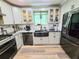 Bright kitchen with stainless steel appliances, granite countertops, and a modern farmhouse style sink at 4086 Rex Road, Rex, GA 30273
