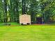 Backyard features a storage shed and covered storage for equipment surrounded by lush greenery at 4086 Rex Road, Rex, GA 30273