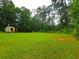 Expansive green yard featuring mature trees and a storage shed, providing ample outdoor space and storage at 4086 Rex Road, Rex, GA 30273