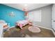 Charming bedroom with blue accent wall, hardwood floors, and whimsical decor offers a playful atmosphere at 1315 Merry Ne Ln, Atlanta, GA 30329