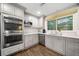 Bright kitchen boasts modern gray cabinetry, stainless appliances, and stylish hardwood floors at 1315 Merry Ne Ln, Atlanta, GA 30329
