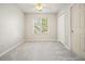 Comfortable bedroom featuring a large window, neutral carpet, and easy closet access at 3366 English Oaks Nw Dr, Kennesaw, GA 30144