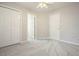 Neutral bedroom featuring plush gray carpeting, ceiling fan, and a classic white door at 3366 English Oaks Nw Dr, Kennesaw, GA 30144