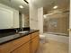 Bright bathroom featuring granite countertop, wood cabinets, and shower with glass enclosure at 195 14Th Ne St # 303, Atlanta, GA 30309