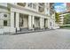Luxury condo entrance featuring large white pillars, a covered entry, and detailed stonework at 195 14Th Ne St # 303, Atlanta, GA 30309