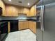 Condo kitchen with stainless steel refrigerator, wooden cabinets, and a black dishwasher at 195 14Th Ne St # 303, Atlanta, GA 30309